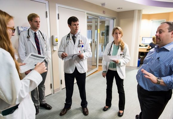 Josh Medow, right, medical director of the Neurocritical Intensive Care Unit at UW Hospital and Clinics, discusses a patientÕs progress with medical students during the groupÕs floor rounds on Aug. 18, 2015. Medow is also associate professor of neurological surgery in the School of Medicine and Public Health (SMPH) at the University of Wisconsin-Madison. (Photo by Jeff Miller/UW-Madison)